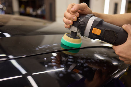 Person using machine to polish black cars automotive exteriorの写真素材