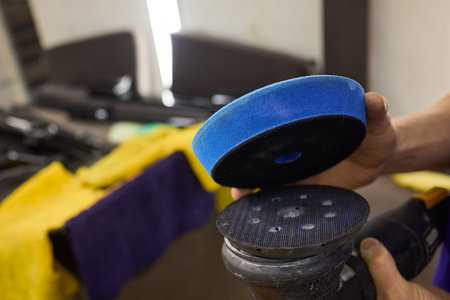 Polishing a car with a yellow sponge for automotive tire shineの写真素材