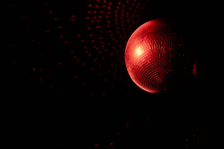 A Disco Ball Shining Red Light, Creating an Energetic Atmosphere Perfect for Celebratingの写真素材