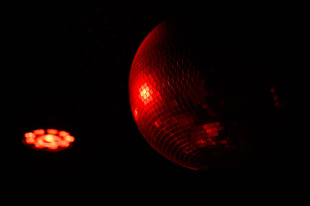 A Disco Ball Shining Red Light, Creating an Energetic Atmosphere Perfect for Celebratingの写真素材
