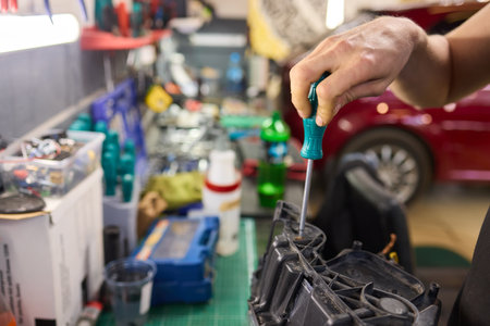 showing hands effectively repairing a car headlight in a workshop environmentの写真素材