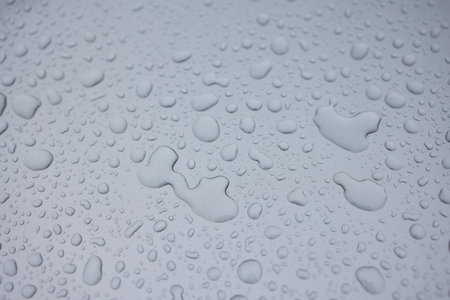 A serene image of water droplets on a smooth surface, capturing a tranquil and peaceful sceneの写真素材