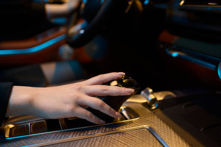 An Elegant Hand Gracefully Resting on the Luxury Car Gear Shift of a Modern Vehicleの写真素材
