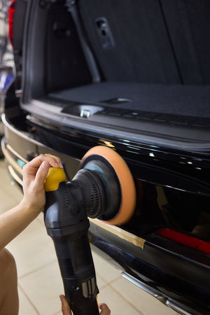 Car detailing enhances shine of vehicle with machine buffer for glossy finishの写真素材