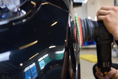 Person using machine to polish black cars automotive exteriorの写真素材
