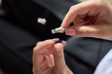 The image shows a closeup of someone gripping a lightning cable that appears to be damaged