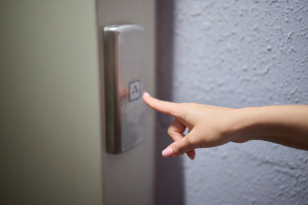 A video displaying a closeup view of someone pushing elevator buttons in an office buildingの写真素材