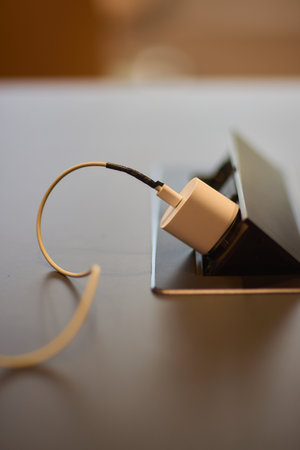 A power cable is connected to the laptop in the picture for charging, an essential accessory wrapped...