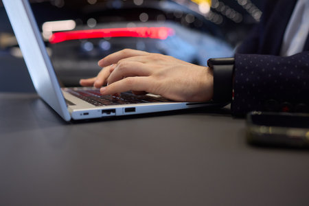 In an office environment, someone is typing on a laptop keyboard using their handsの写真素材