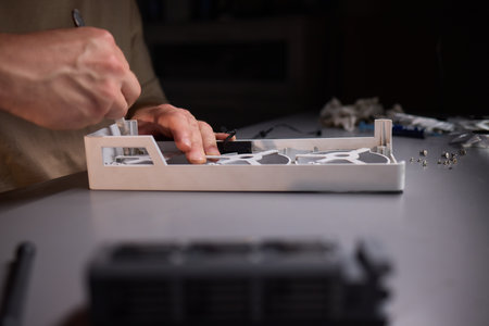 A technician is skillfully repairing a computer GPU fan with precision tools in a workshop