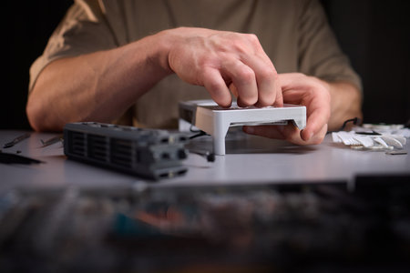 A technician is skillfully repairing a computer GPU fan with precision tools in a workshopの写真素材