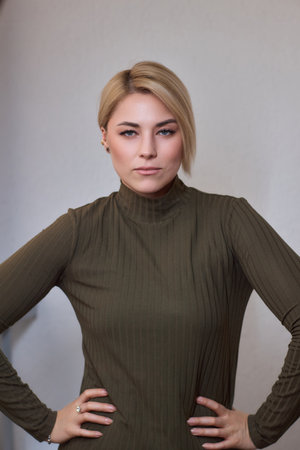 A professional businesswoman in a green turtleneck portrayed in a serene and elegant manner