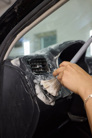 Car Interior Cleaning process underway with a brush for detailed professional detailingの写真素材