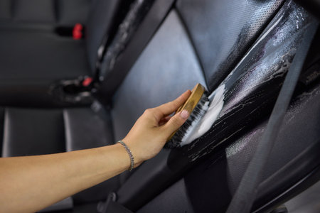 Clean leather car seats with brush and plastic cover for luxury interior maintenance and hygieneの写真素材
