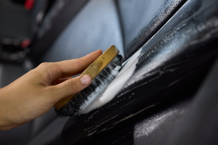 Clean leather car seats with brush and plastic cover for luxury interior maintenance and hygieneの写真素材