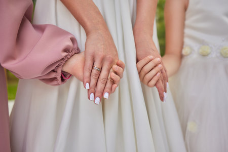 Elegant Wedding Moment Bridal and Bridesmaids Holding Hands in a Special Moment of Unity and Loveの写真素材