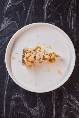 A Deliciously Crafted Slice of Almond Cake with a Beautiful Mango Glaze on an Elegant Plateの写真素材