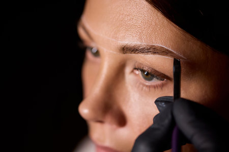 Eyebrow Styling Techniques Using Precision Tools During a Comprehensive Beauty Sessionの写真素材