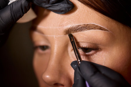 Eyebrow Styling Techniques Using Precision Tools During a Comprehensive Beauty Sessionの写真素材