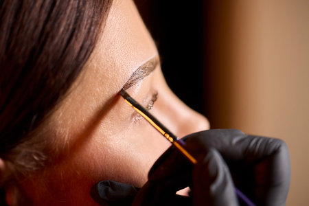 Eyebrow Styling Techniques Using Precision Tools During a Comprehensive Beauty Sessionの写真素材