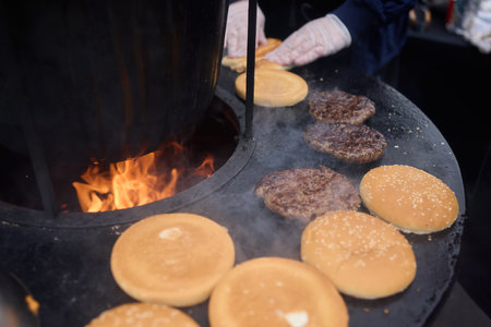 Sizzling, Mouthwatering Burgers Cooking Perfectly on a Griddle at a Summer BBQ Eventの写真素材