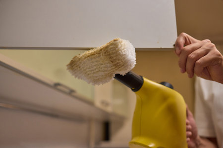 A man uses an innovative cleaning tool in his modern kitchen for cleanliness and organizationの写真素材