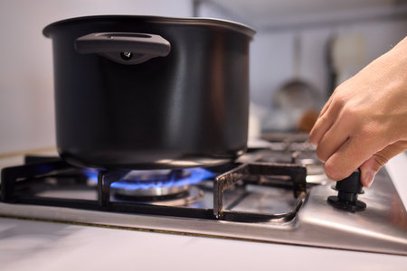 Cooking delicious meals on a modern gas stove using a sleek black pot is an artの写真素材