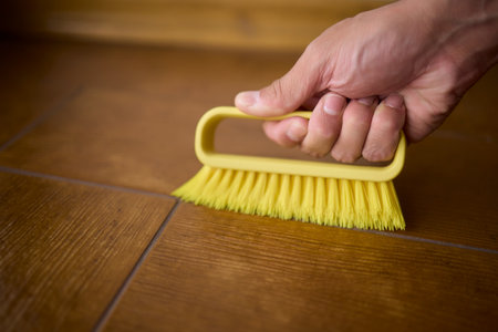 Cleaning a Wooden Floor using a Yellow Brush for Optimal Hygiene and Cleanliness
