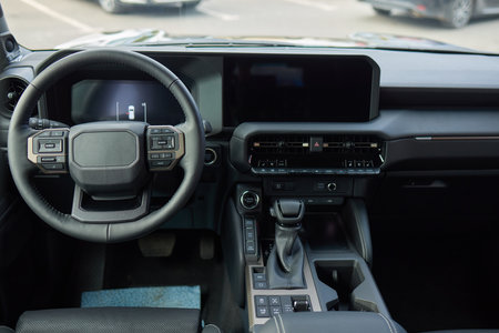 Closeup of a modern car steering wheel with control buttons for technology and convenienceの写真素材