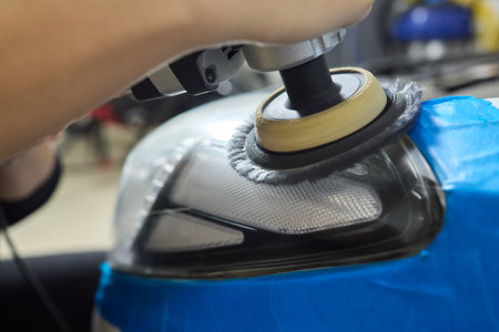 Person using a machine to polish automotive lighting on a car headlightの写真素材