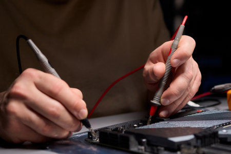 Hands Engaged in Working with Various Electronic Components and Multimeter Testing Processes