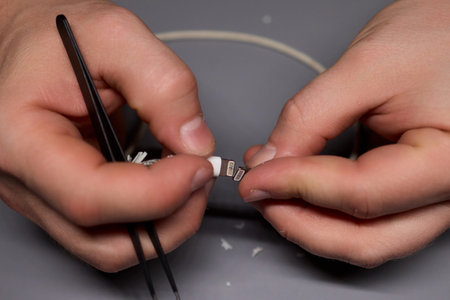 Hands Firmly Holding USB and Connector Cables for the Purpose of Electronics Repair Workの写真素材