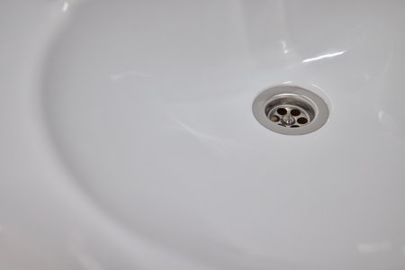 Effectively Hand Cleaning a Sink Using a Sponge and Gloves for Optimal Cleanlinessの写真素材