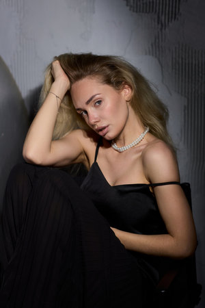 An Elegant Woman in a Beautiful Black Dress Posing Elegantly with Grace and Charmの写真素材
