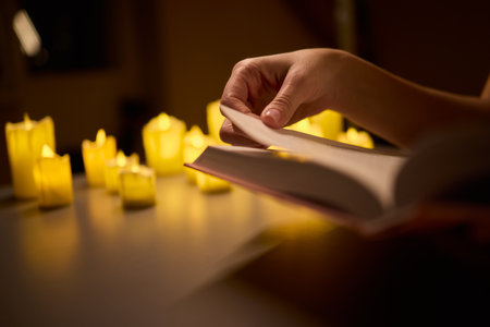 Indulging in Cozy Reading Under Candlelight for a Relaxing and Peaceful Evening Escapeの写真素材