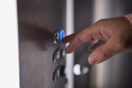 Pressing the elevator button in contemporary high rise buildings signifies modern urban convenience
