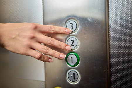 Pressing the elevator button in contemporary high rise buildings signifies modern urban convenience