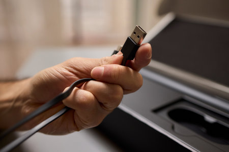 A Hand Grasping a USB Cable to Enhance Connectivity and Address Essential Data Transfer Needsの写真素材