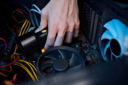 A vacuum is being used to clean a computer case in a bright room, showing workspace maintenanceの写真素材