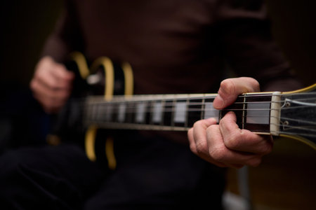 Close Up of Hands Playing a Guitar in a Warm and Cozy Setting Filled with Music and Art