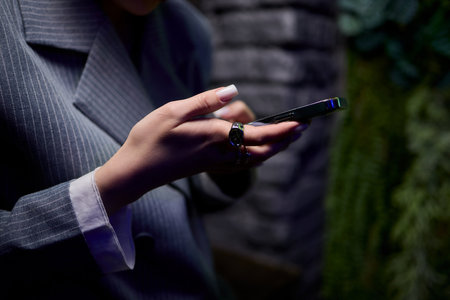 A Stylish Young Woman Enjoying Herself while Engaging with Her Phoneの写真素材
