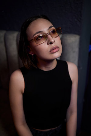 A stylish woman struts into the bar at night, exuding elegance of nightlife