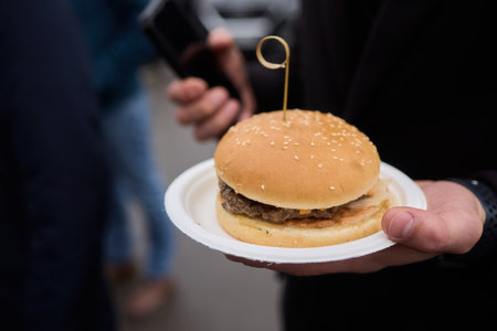 A Delicious Hamburger Served on a Plate, Perfectly Placed in My Hand for Enjoyment