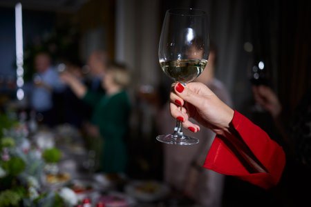 Cheers to a Fantastic Celebration Friends Joyfully Toasting with Wine Glasses in Handの写真素材