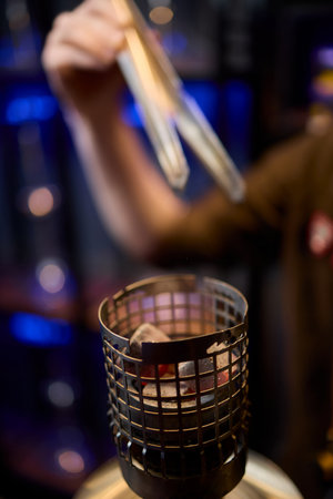 Close up of a hookah made of metal and glass on a wooden tableの写真素材