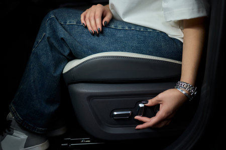 Positioning car seat by hand for optimal comfort and ergonomic support while drivingの写真素材