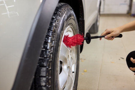 Cleaning car wheel thoroughly with brush and soap for maintenance and shiny resultの写真素材