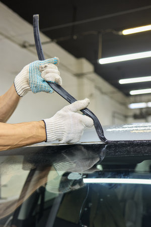 Automobile special workers remove old windscreen or windshield of a car in auto service station garage. Backgroundの写真素材