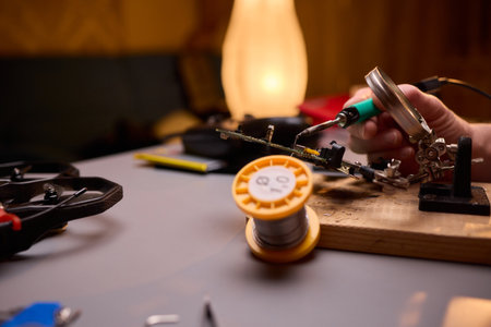 Hands Carefully Repairing a Circuit Board with a Soldering Tool for Electronics Projects