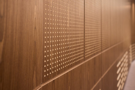 Artistic Wooden Wall with Perforated Design showcases the beauty and craftsmanship of modern decorの写真素材